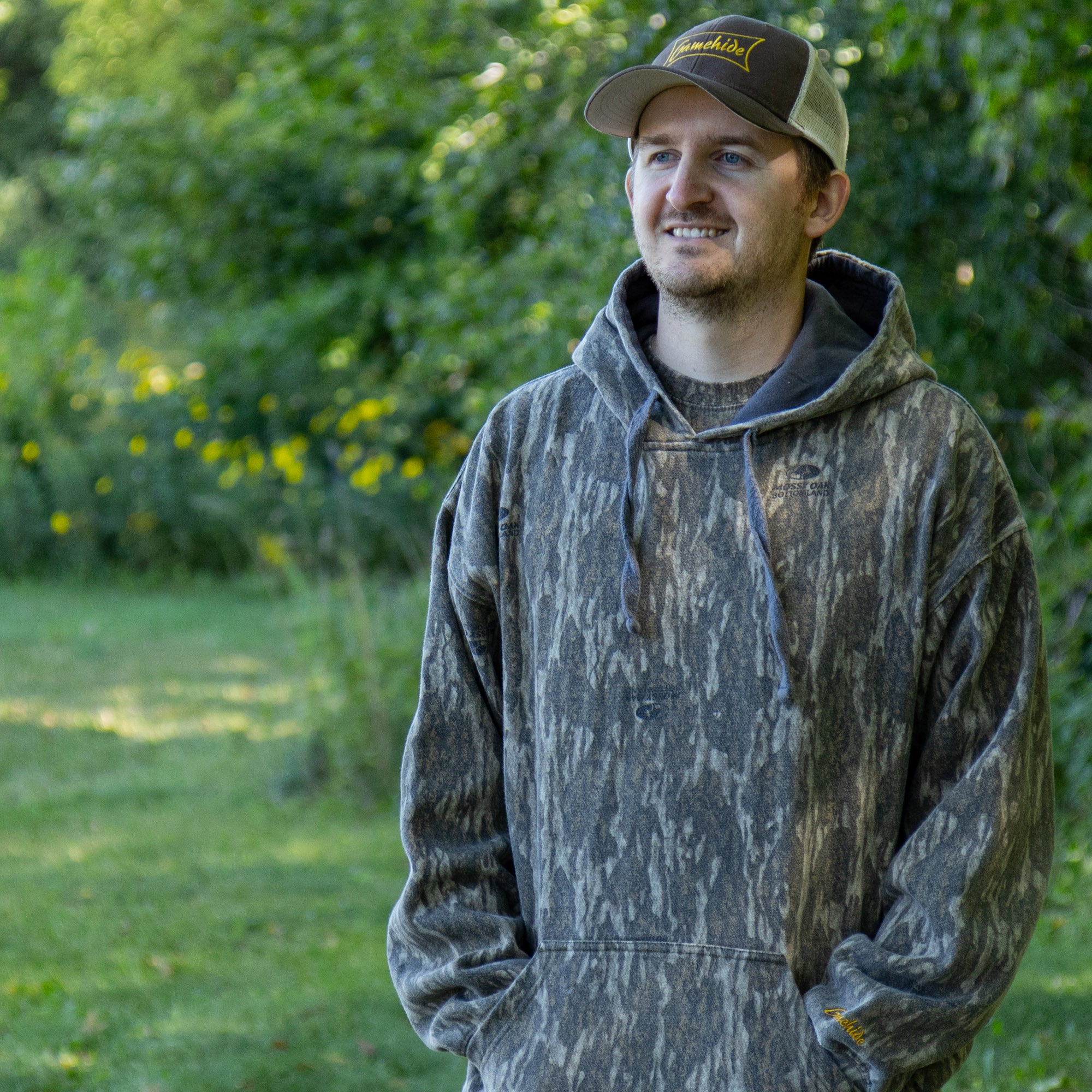 lifestyle image of man wearing hooded sweatshirt in camo