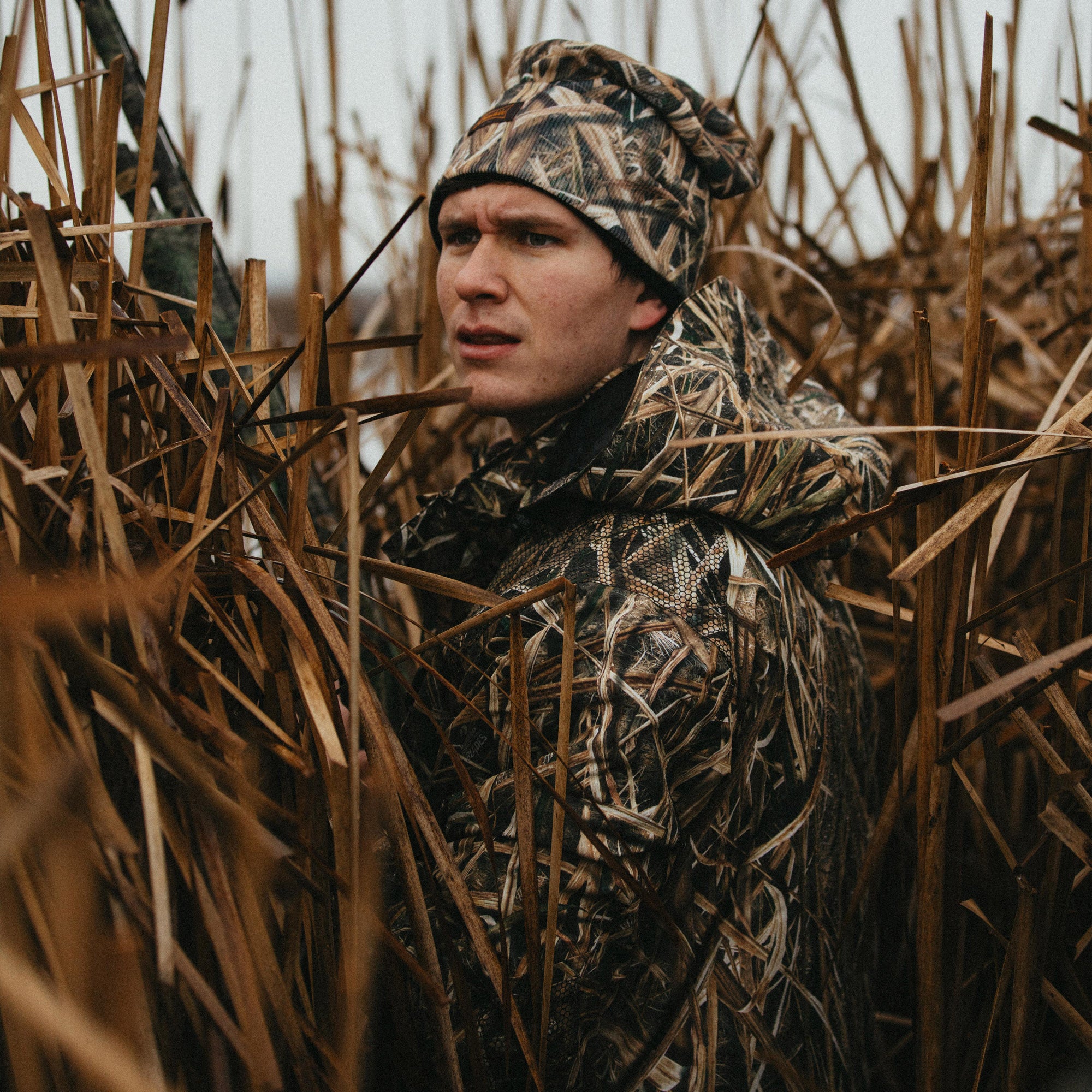 waterfowl hunter in cattail wearing shadow grass camo