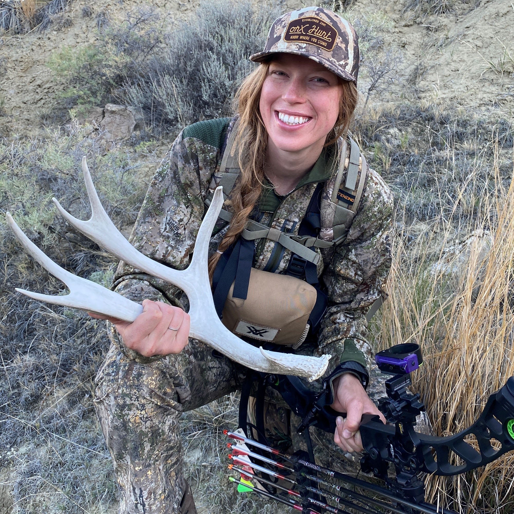 woman holding bow and shed antler
